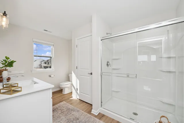 a bathroom with a sink a toilet and shower