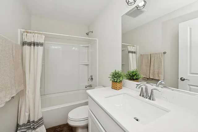 a bathroom with a sink a toilet a tub and shower