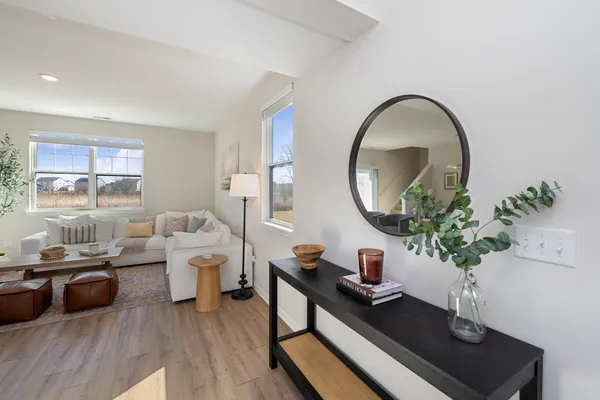 a living room with furniture a mirror and a potted plant
