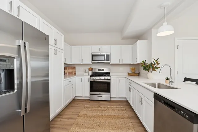 a kitchen with white cabinets and stainless steel appliances