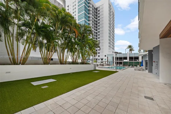 a view of swimming pool with outdoor seating and a garden