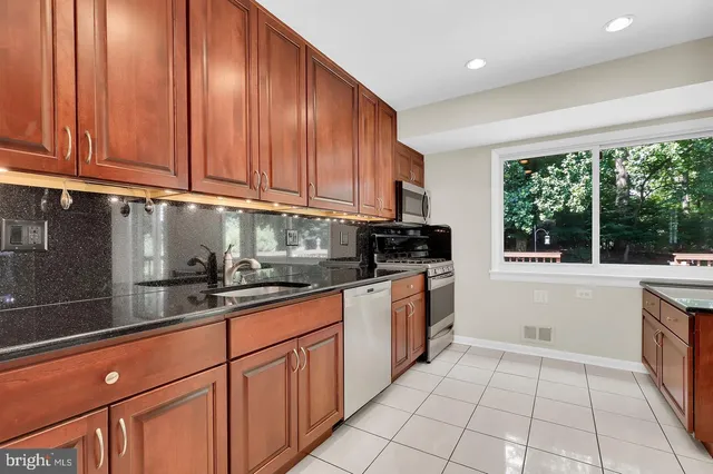 a kitchen with stainless steel appliances granite countertop a refrigerator sink and cabinets