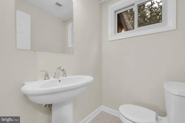 a bathroom with a sink a toilet and mirror