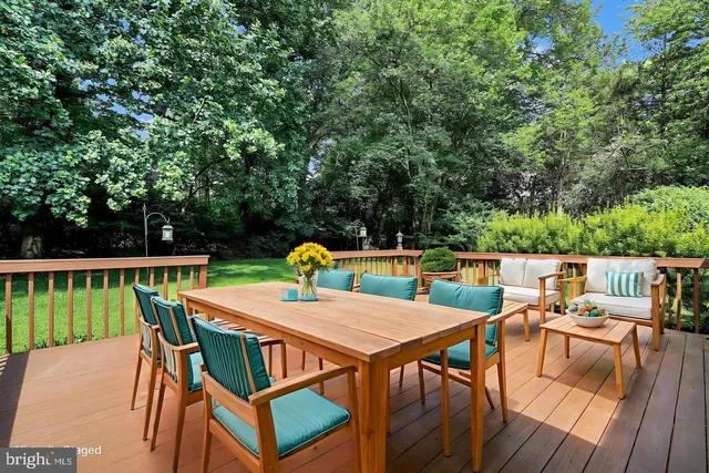 a roof deck with a dining table and chairs with wooden floor