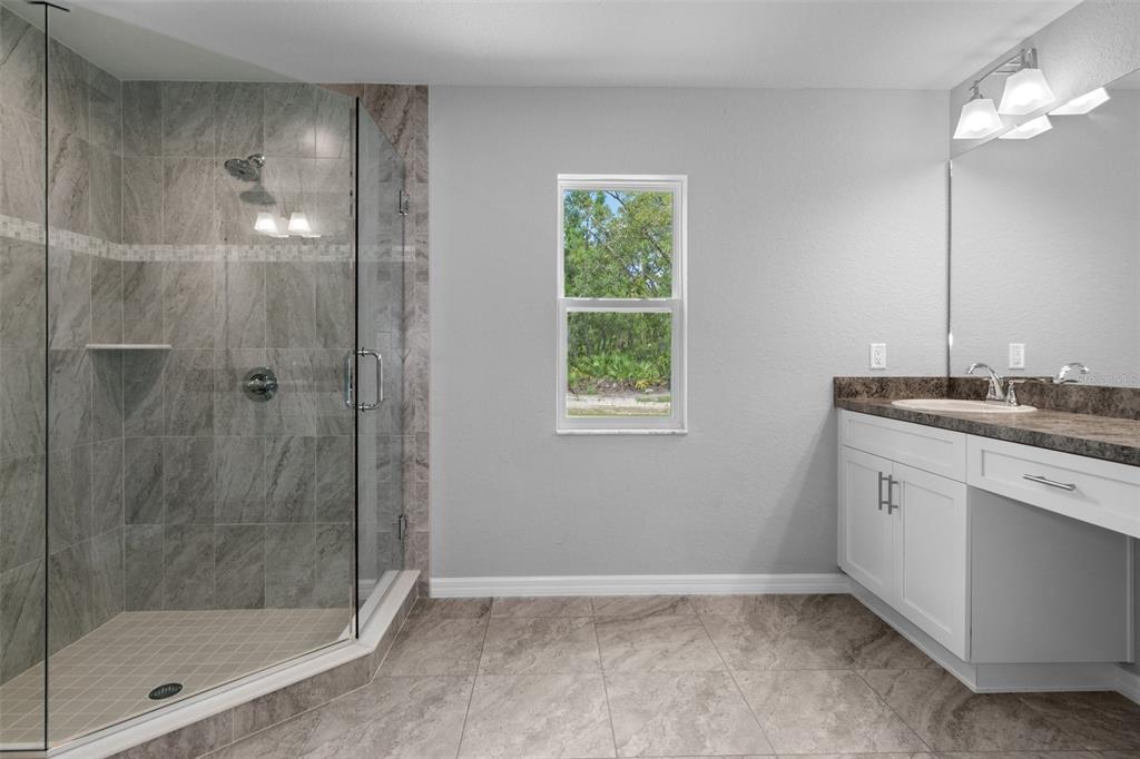 2492 Lackland Avenue Spring Hill, FL 34608 - Photo 17 of 30 a bathroom with a granite countertop sink a shower and a mirror