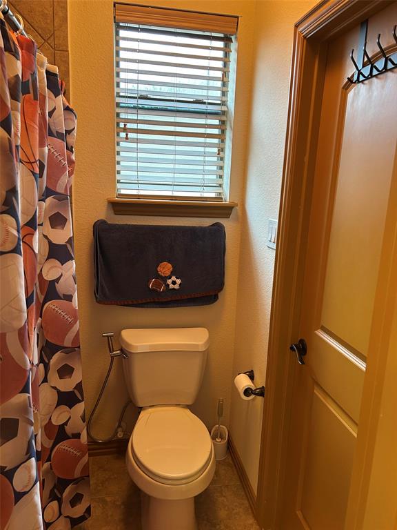 2219 Longview Road Irving, TX 75063 - Photo 31 of 36 a bathroom with a toilet and a shower curtain