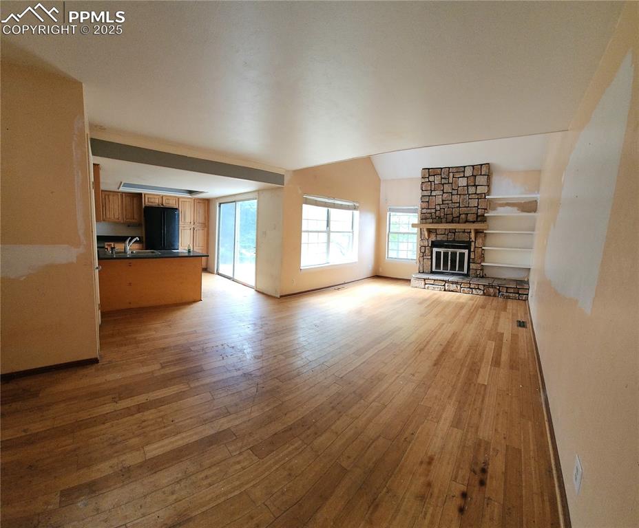 290 Cobblestone Drive Colorado Springs, CO 80906 - Photo 5 of 30 an empty room with wooden floor and a kitchen