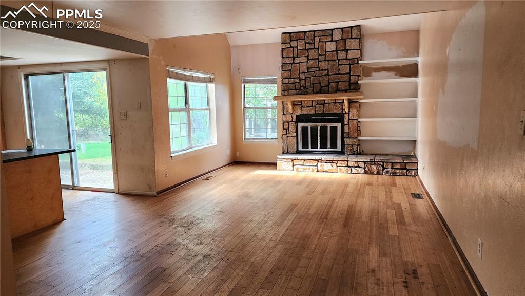 290 Cobblestone Drive Colorado Springs, CO 80906 - Photo 6 of 30 wooden floor in an empty room with a fireplace