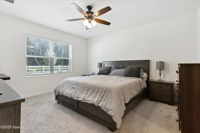 a bedroom with a bed and ceiling fan