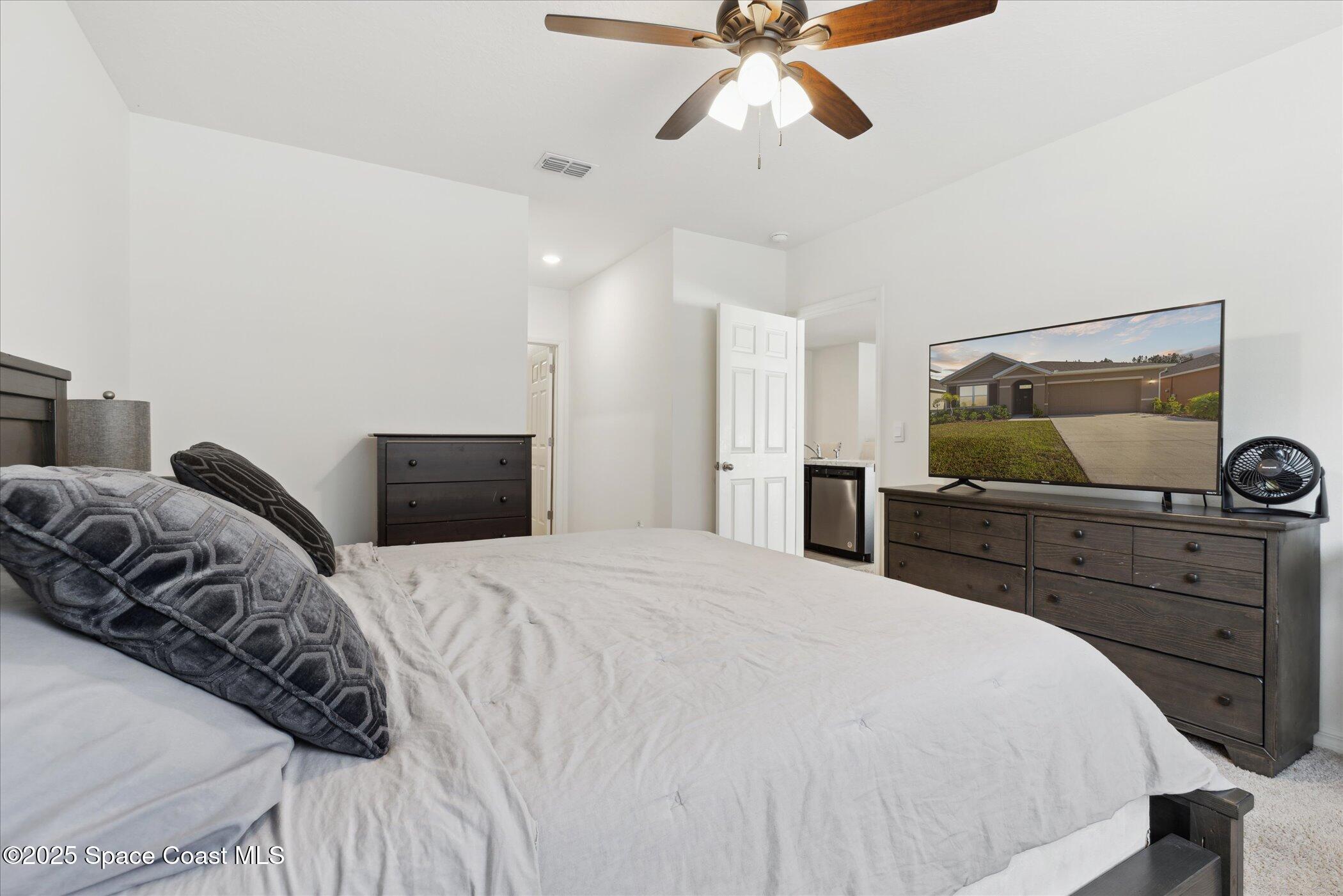 967 Trinity Street Rockledge, FL 32955 - Photo 18 of 40 a bedroom with a bed and ceiling fan