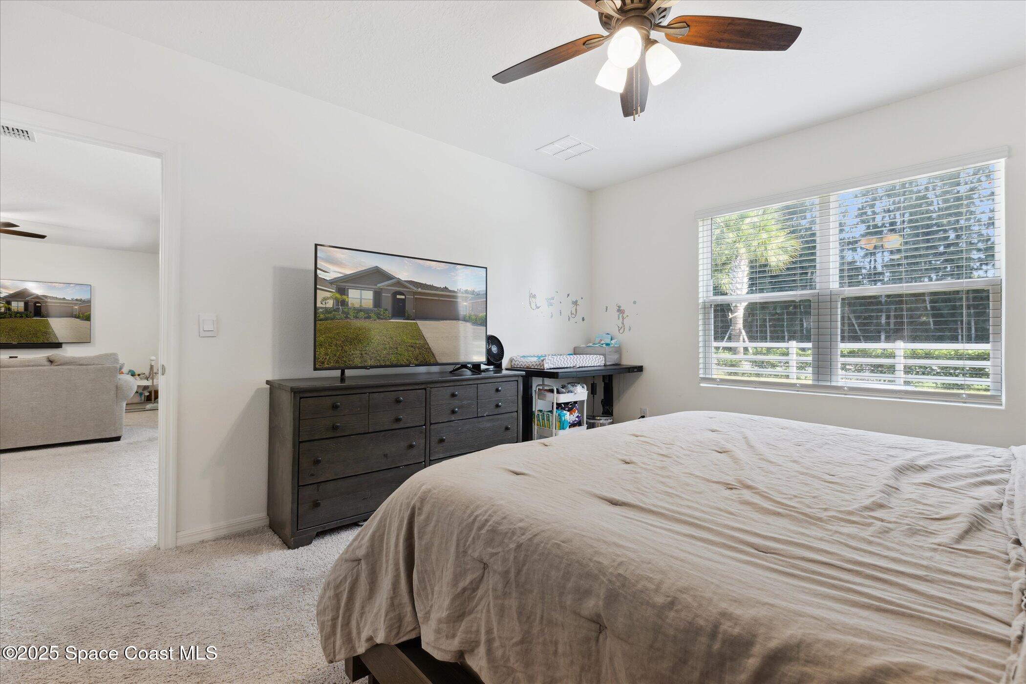 967 Trinity Street Rockledge, FL 32955 - Photo 20 of 40 a bedroom with a bed and a flat screen tv