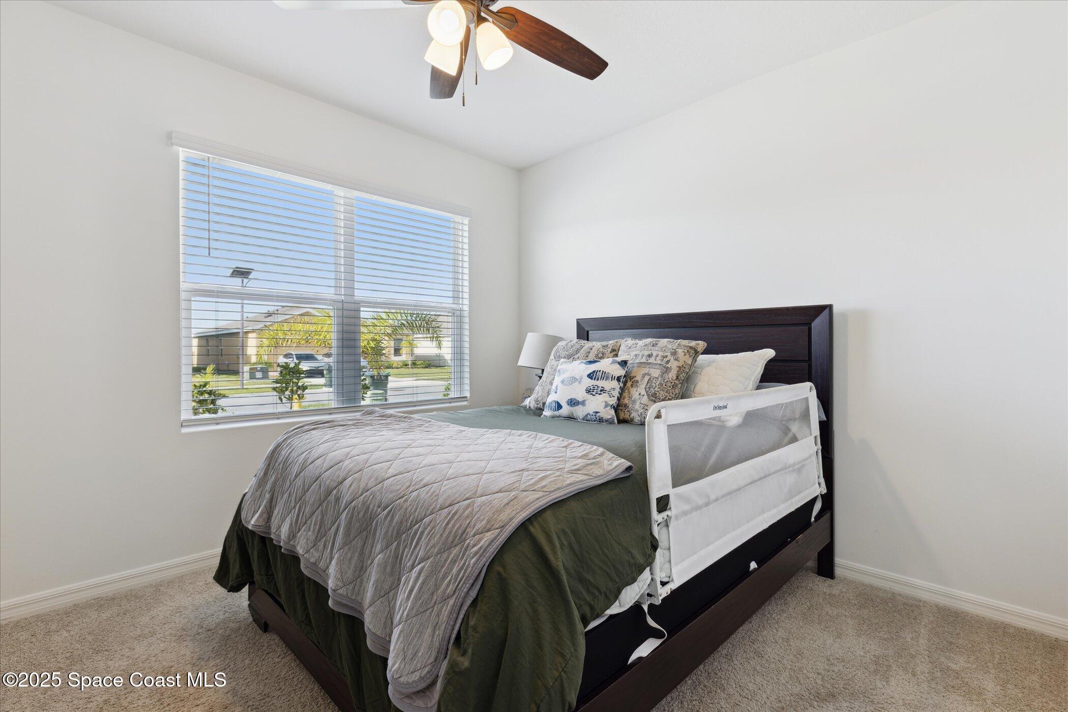 967 Trinity Street Rockledge, FL 32955 - Photo 29 of 40 a bed sitting in a bedroom next to a window