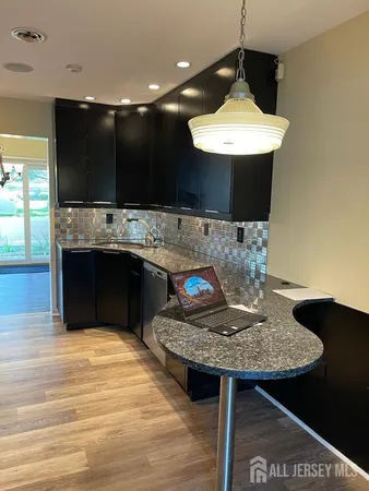 a kitchen with kitchen island granite countertop a sink and a stove