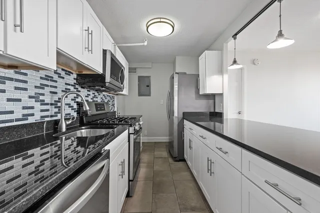 a kitchen with stainless steel appliances a sink stove and cabinets