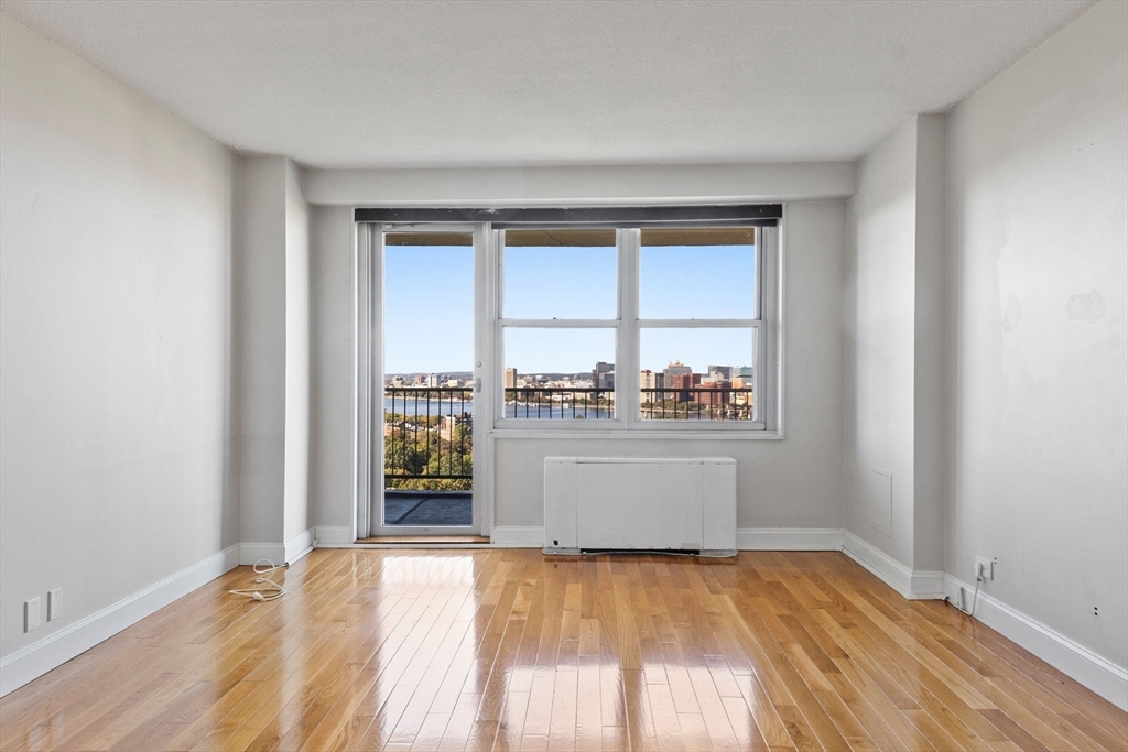 151 Tremont Street, Unit 24P Boston, MA 02111 - Photo 16 of 38 wooden floor in an empty room with a window