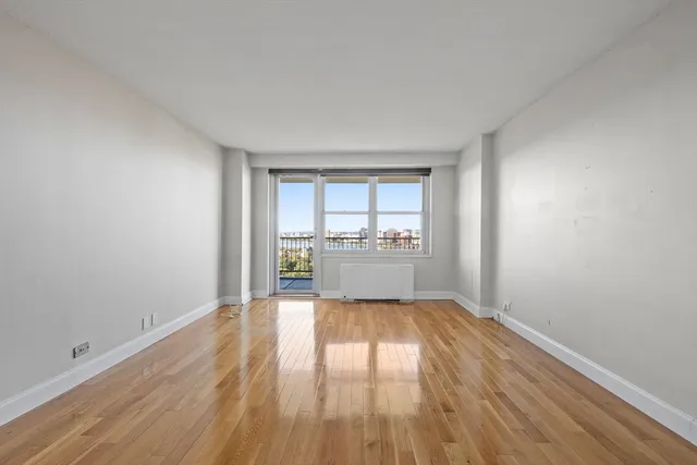 a view of a room with wooden floor and a kitchen