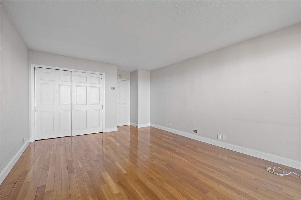 151 Tremont Street, Unit 24P Boston, MA 02111 - Photo 24 of 38 a view of an empty room with wooden floor