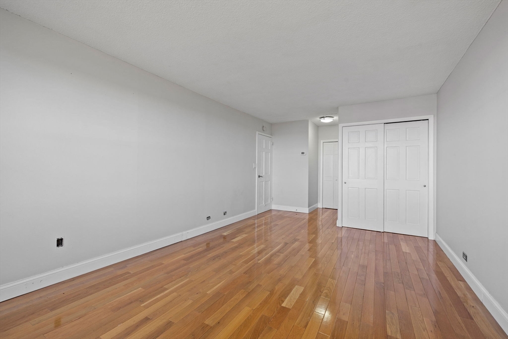 151 Tremont Street, Unit 24P Boston, MA 02111 - Photo 27 of 38 a view of an empty room and wooden floor
