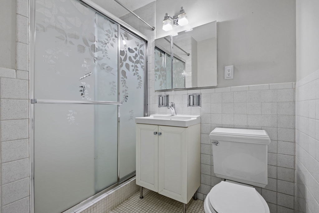 151 Tremont Street, Unit 24P Boston, MA 02111 - Photo 28 of 38 a bathroom with a toilet sink and mirror