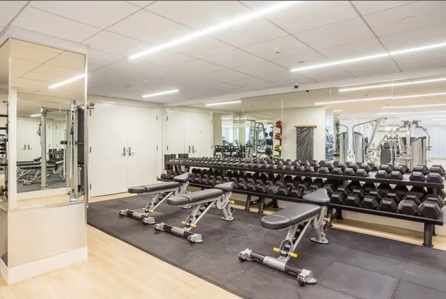 a room with gym equipment and large mirror