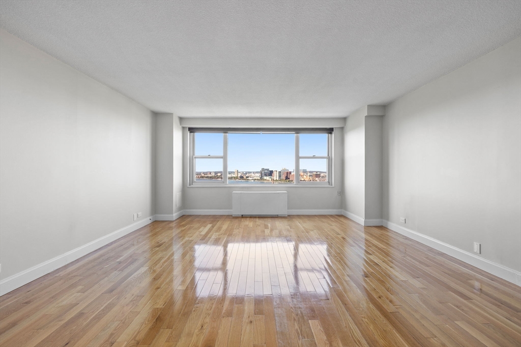 151 Tremont Street, Unit 24P Boston, MA 02111 - Photo 6 of 38 wooden floor in an empty room with a window