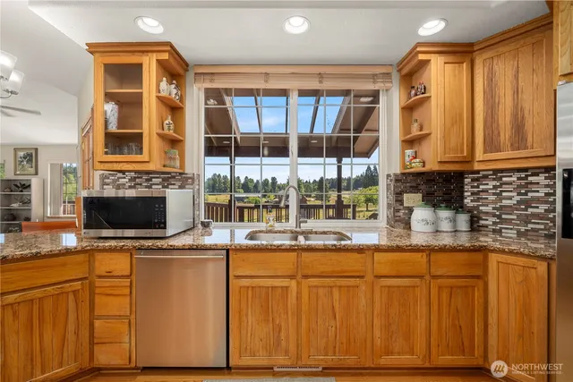 a kitchen with stainless steel appliances granite countertop a sink and a microwave