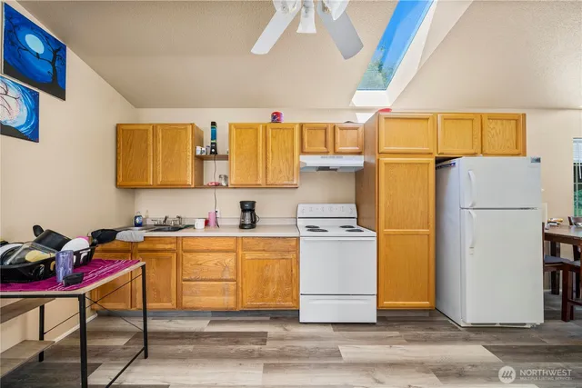 a kitchen with a refrigerator cabinets and wooden floor