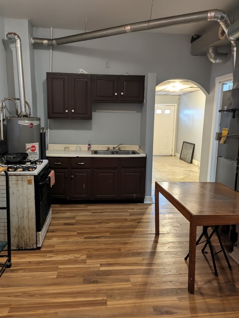 4805 South Elizabeth Street Chicago, IL 60609 - Photo 12 of 18 a large kitchen with stainless steel appliances granite countertop a sink and a stove