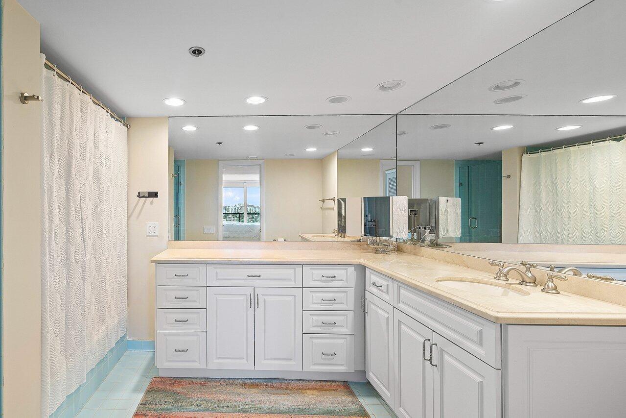250 South Ocean Boulevard, Unit 10C Boca Raton, FL 33432 - Photo 11 of 33 a large bathroom with a granite countertop sink and a mirror