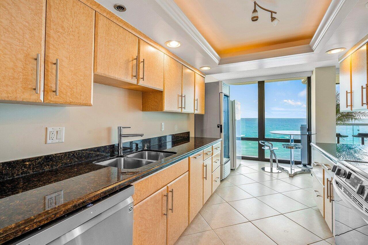 250 South Ocean Boulevard, Unit 10C Boca Raton, FL 33432 - Photo 6 of 33 a kitchen with granite countertop a sink and a stove