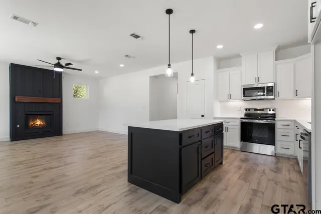 a kitchen with stainless steel appliances granite countertop a stove a refrigerator and a oven