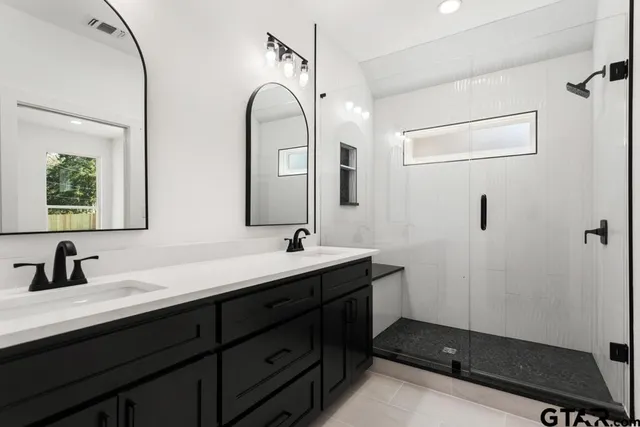 a bathroom with a double vanity sink and mirror