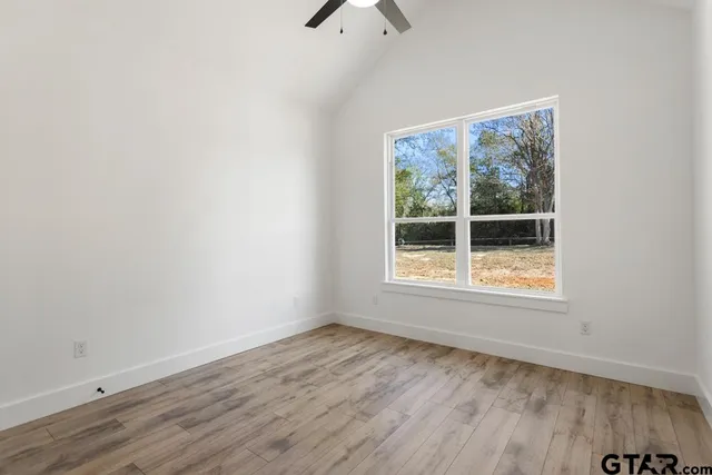 an empty room with a window and wooden floor