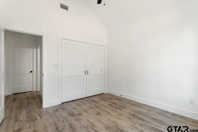 a view of an empty room with wooden floor
