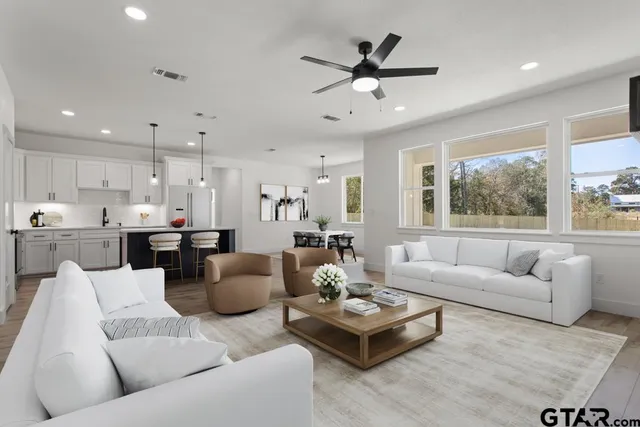 a living room with furniture kitchen and a large window