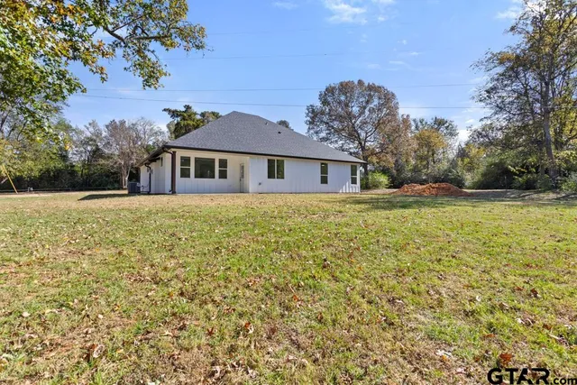 a view of a yard with plants and trees