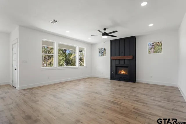 a view of an empty room with a window and fireplace