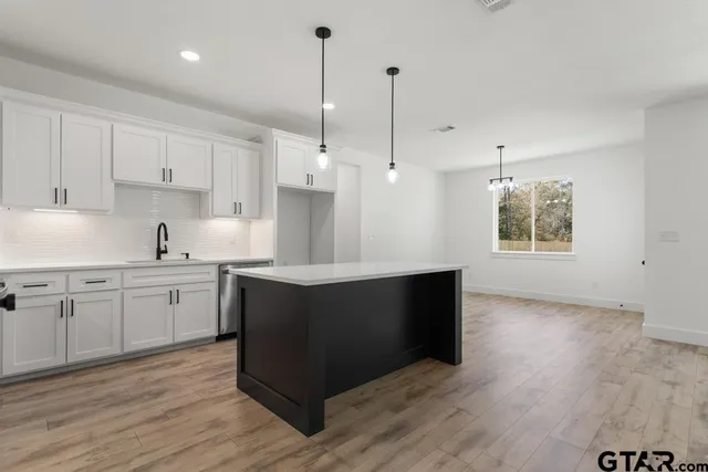 a kitchen with sink cabinets and wooden floor