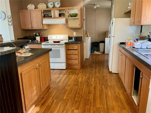 a kitchen with wooden floors and refrigerator