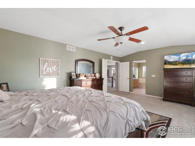 a bedroom with a large bed and a chandelier