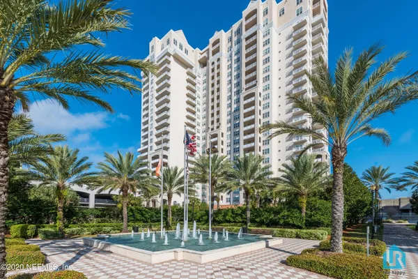 a view of a livingroom with furniture a fireplace wooden floor and chandelier
