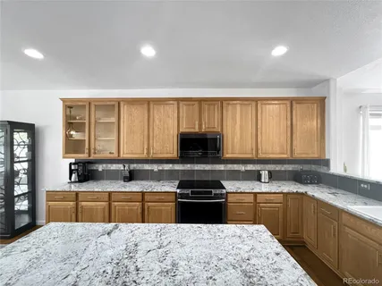 a kitchen with stainless steel appliances granite countertop a sink a stove a microwave a sink a counter space and cabinets