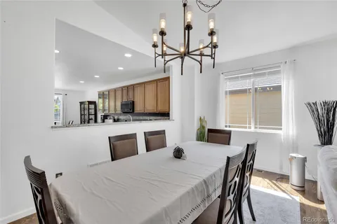 a kitchen with stainless steel appliances kitchen island granite countertop a table chairs and a refrigerator
