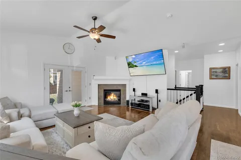 a living room with furniture a fireplace and a ceiling fan