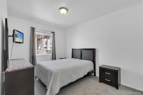 a bedroom with a bed and a lamp on dresser