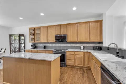 a kitchen with stainless steel appliances granite countertop a sink stove and cabinets