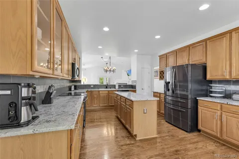 a kitchen with stainless steel appliances granite countertop a sink refrigerator and cabinets