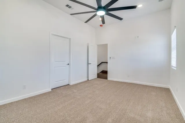 an empty room with closet and a chandelier fan
