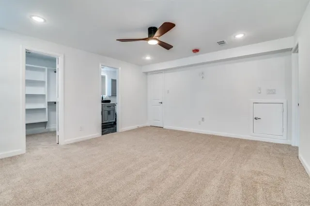 an empty room with closet and a ceiling fan