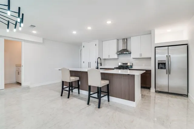 a kitchen with a refrigerator and white cabinets